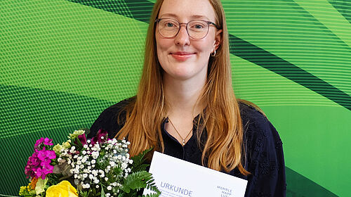 Lara Baumbach honoured for her Bachelor’s thesis Lara Baumbach holds her certificate and a bouquet of flowers after receiving an award for her bachelor’s thesis.