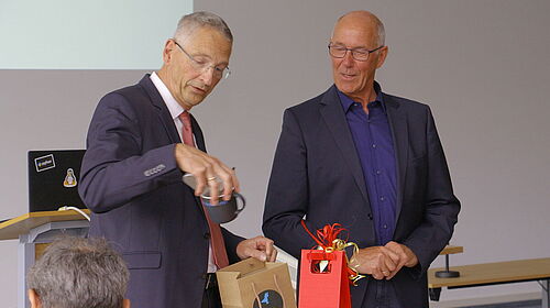 Prof. Dr.-Ing. Ingo A. Müller (links), Dekan der Fakultät für Ingenieurwissenschaften, überreicht Emeritus Prof. Dr.-Ing. Michael Rachow ein Abschiedsgeschenk – die tradionelle "Fakultätstasse".