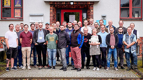 Gruppenbild der 35 ehemaligen sowie aktuellen Mitglieder der Forschungsgruppe CEA vor Haus 17 auf dem Campus der Hochschule Wismar